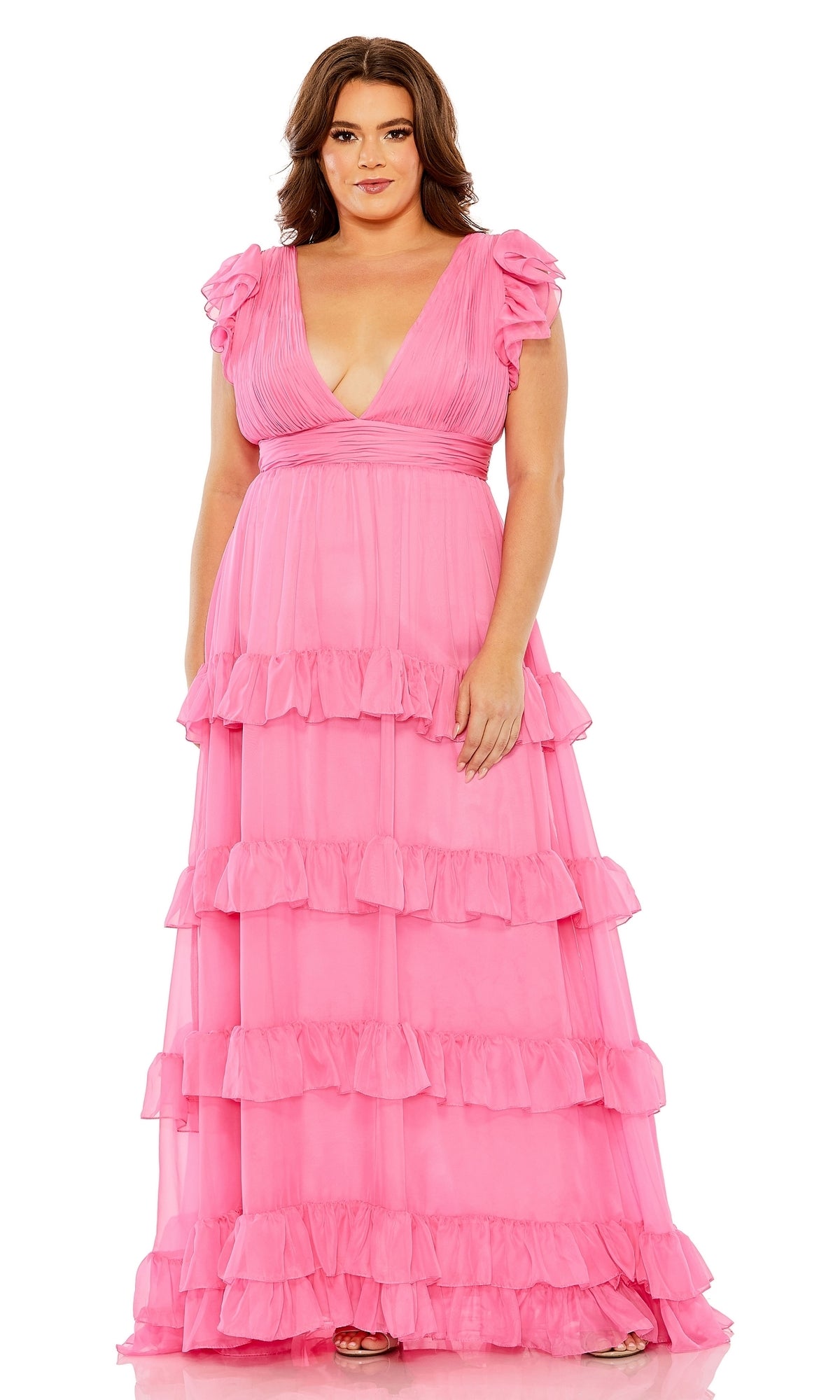 A woman faces forward in the Long Plus-Size Formal Dress 68544 by Mac Duggal, a floor-length pink ruffle gown with short flutter sleeves and a deep V-neckline—an elegant A-line choice for special occasions.